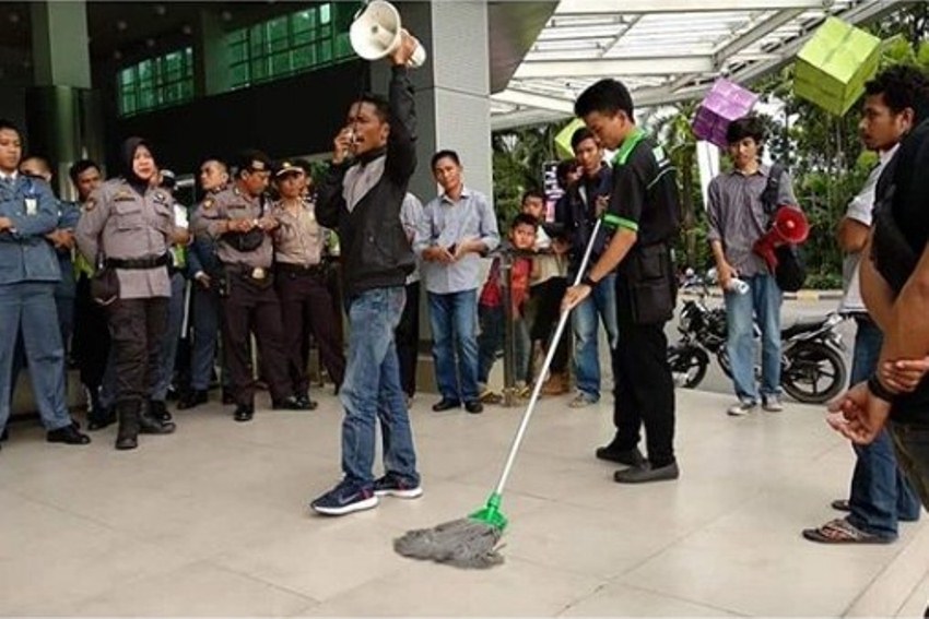 Tetap Bersih-Bersih di Tengah Demo Boikot Dilan 1991, Aksi Cleaning Service ini Jadi Sorotan