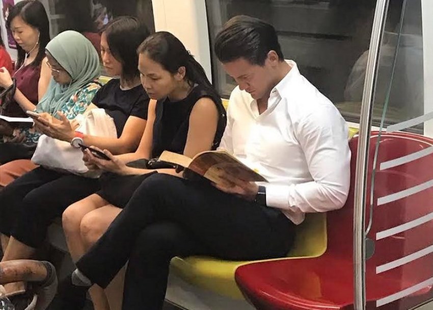 Duduk Silang Kaki Sambil Baca Buku di Dalam MRT, Potret Pria Tampan ini Viral