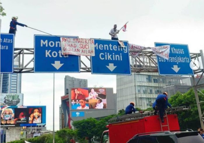 Heboh Seorang Pria Panjat Papan Jalan di Sudirman