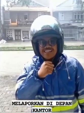 Viral! Aksi Karyawan Beri Laporan Cuaca di Depan Kantornya saat Hujan Deras